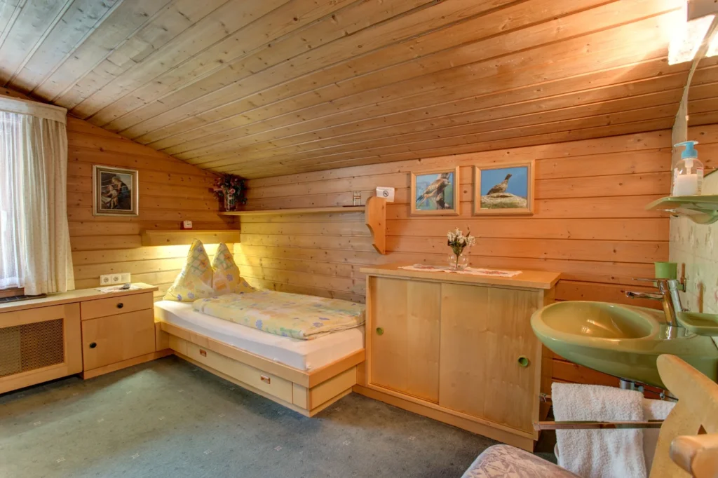 Einzelzimmer in der Alpenruh mit Holzverkleidung und Waschbecken